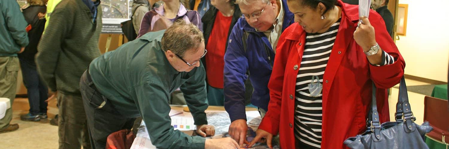 Members of the public looking at a map for a planning study. 