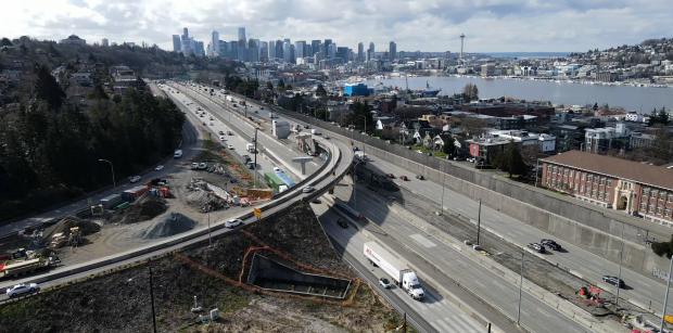A drone shot of West Bound 520 overlooking a view of downtown seattle.