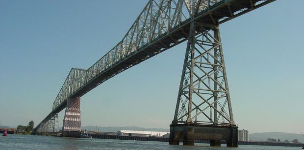 A show from below of the Lewis & Clark Bridge, a large bridge spanning a wide body of water