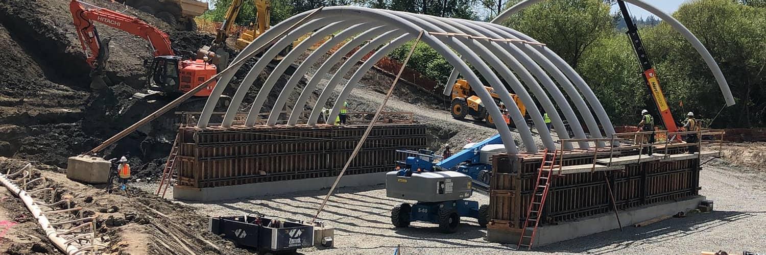 Construction workers and equipment building a highway structure 