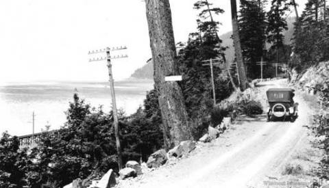 View of car on Chuckanut Drive near south end of segment, ca 1916.