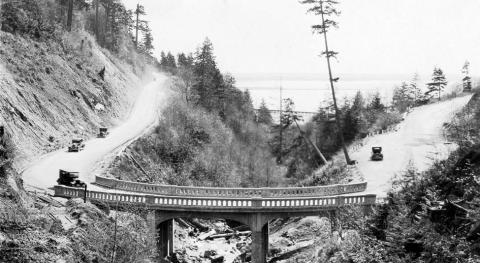 View of Oyster Creek Bridge with four vehicles approaching the bridge and bay in the background. 1925