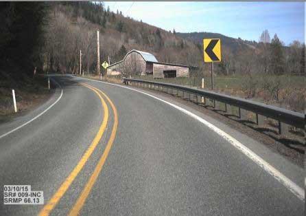 View from road of typical limited sight distance road sign and rural landscape on the historic SR 9 historic segment at MP 66.13, with barn in background