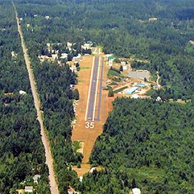 The Apex landing strip in the middle of trees with a clear patch of land for landing.