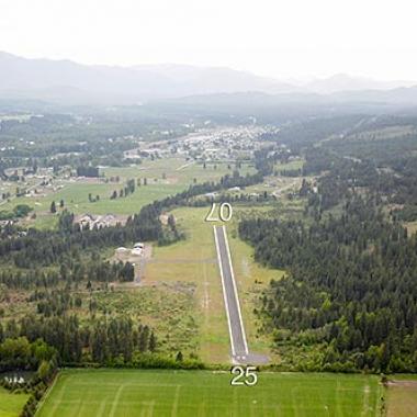 The runway at Cle Elum Municipal airport surrounded by lush greenery. 