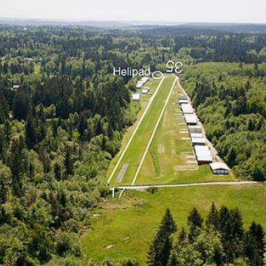 The runway at Vashon Municipal airport surrounded by trees and greenery. 