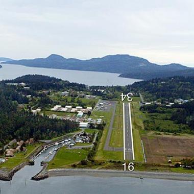 Orcas Island Airport Runway in the middle of a forest near a body of water.