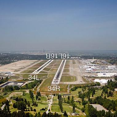 Seattle Tacoma International runway located on a flat area surrounded by grass and roadways.