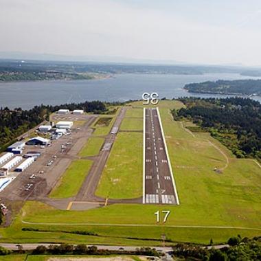 Tacoma Narrows Airport runway on flat grasslands and near the water.