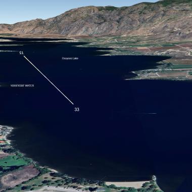 Satellite view of Osoyoos Lake with labeled measurements and surrounding fields and mountains.