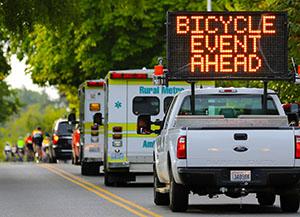 Photo of bicycle event ahead electronic sign on escort truck.
