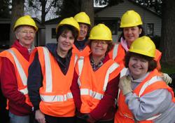 Image of litter removal volunteers in safety vests and hard hats.
