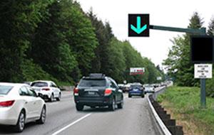 Image of a conceptual shoulder lane control sign over a shoulder lane with supplemental side variable message sign and static sign.