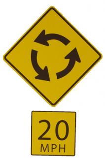 Graphic of a roundabout ahead warning symbol sign with 20 mph advisory speed plaque below.