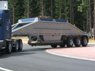 Image of a truck trailer with the trailer wheels on the truck apron of the roundabout central island.