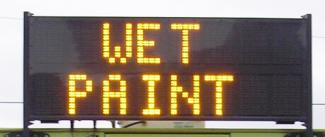 Image of truck mounted variable message sign reading "wet paint".