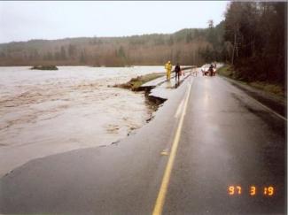 Photo of 1997 flooding of at the Hoh River Site 1, looking upstream. Part of road has been washed out.