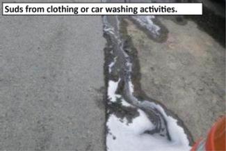 Suds from clothing or car washing activities flowing down pavement.