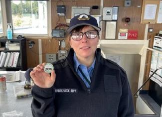 Ferry crewmember holding up a coin