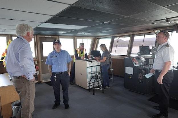 Several people in the pilothouse of a ferry