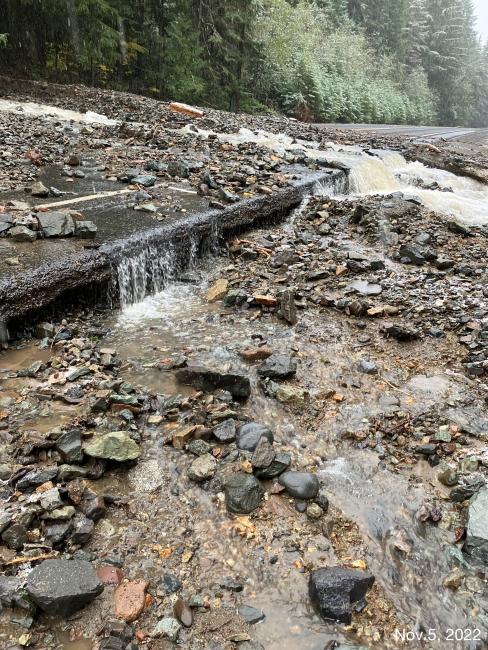 Water and debris flow across State Route 410 after heavy early November rains.