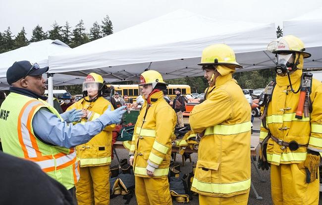 Ferry employee speaking to three people dressed in firefighting gear