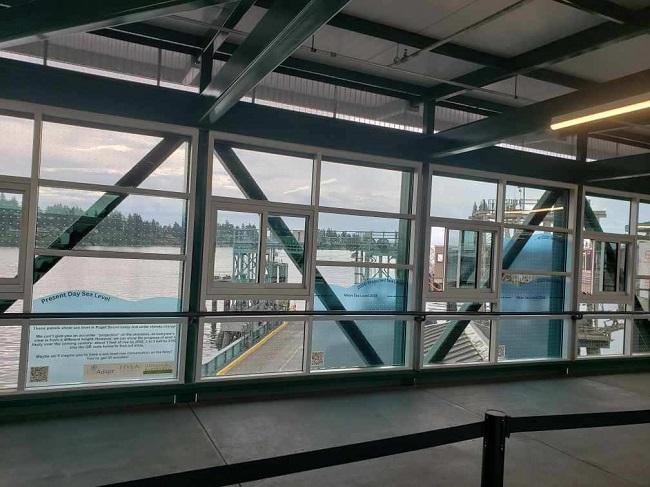 Sea level rise graphics on windows of Bainbridge terminal overhead loading walkway