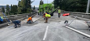 A group of WSDOT workers making surface repairs on a bridge.