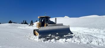A dozer sits on top of the snow covering the Artist Point parking lot.