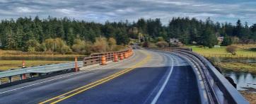 Curved road winding through fields and trees